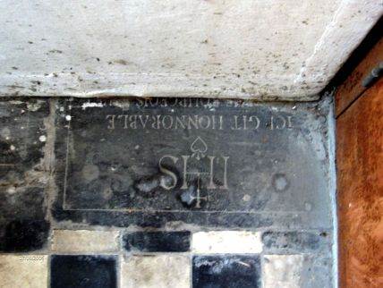 Het nog zichtbare gedeelte van de grafsteen in de verwarmingsruimte van de kerk.